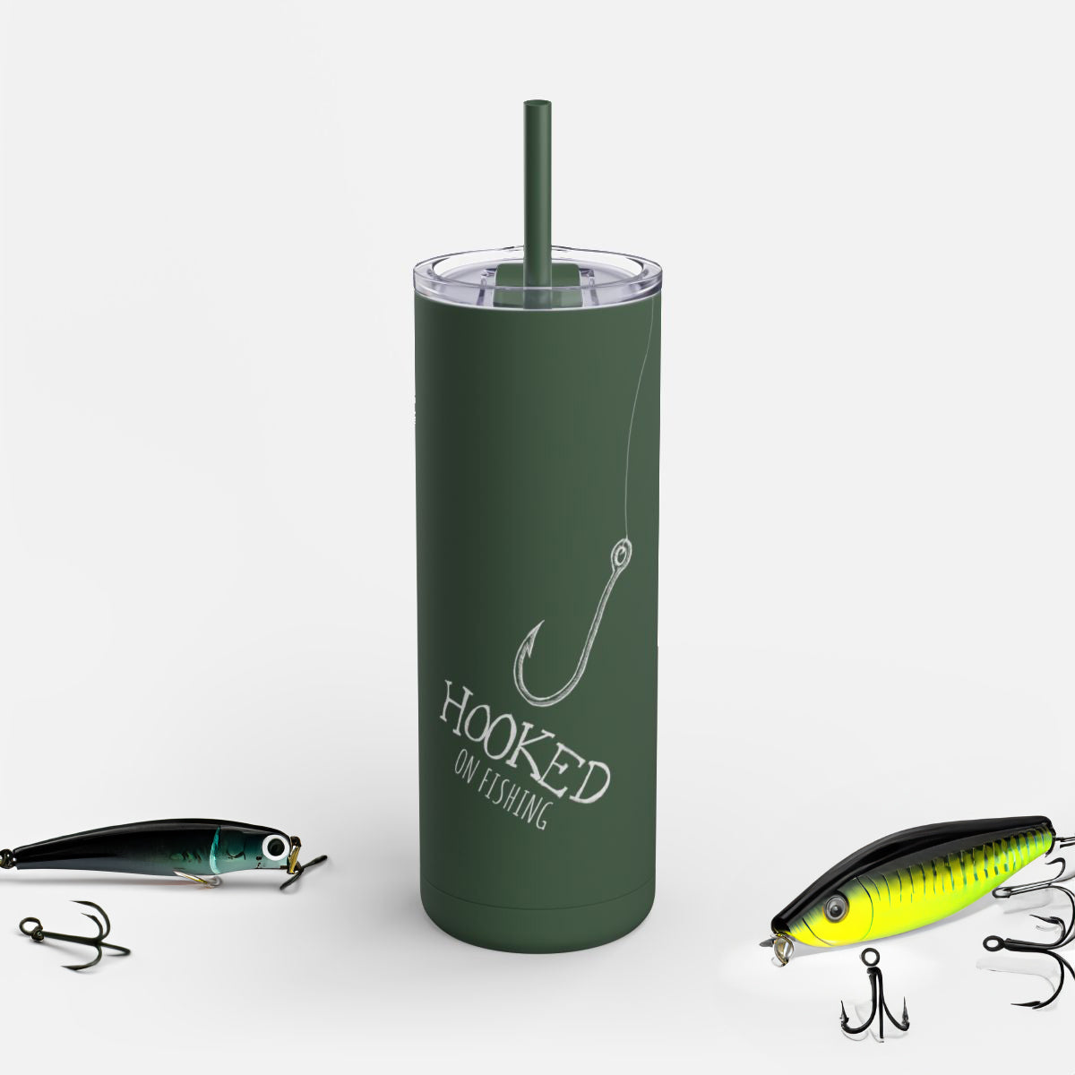 Personalized ‘Hooked on Fishing’ tumbler with a fish hook and line illustration. Perfect gift for anglers, fishing enthusiasts, and outdoor lovers. Keeps drinks hot or cold, ideal for fishing adventures on a white background surrounded by fishing tackle.