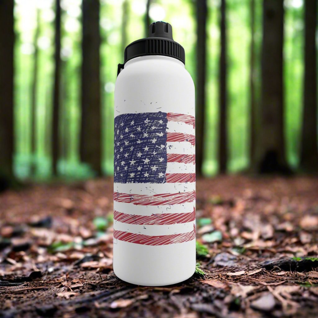 Lifestyle photo of a stainless steel water bottle with an illustrated American flag design, placed in a wooded outdoor setting, highlighting its durability and eco-friendly style.